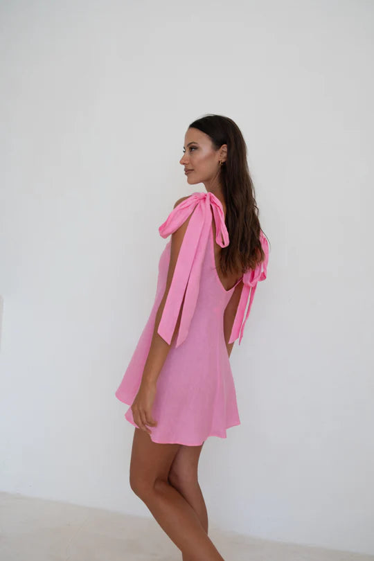 Model wearing Caitlin Crisp Mini Wilmer, showcasing the low back and adjustable shoulder ties - Designer Dress Rental from Lend the Label
