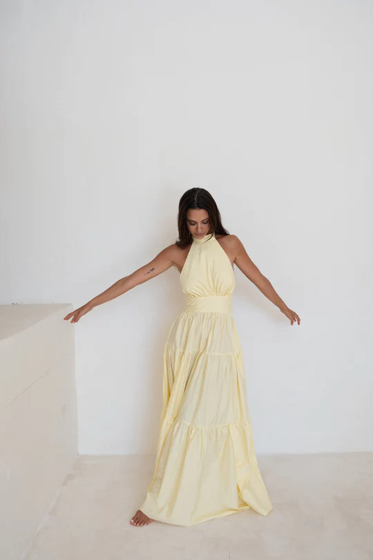 Model showcasing full length Audrey Dress in Butter Yellow with halter neck - designer dress rental from Lend the Label
