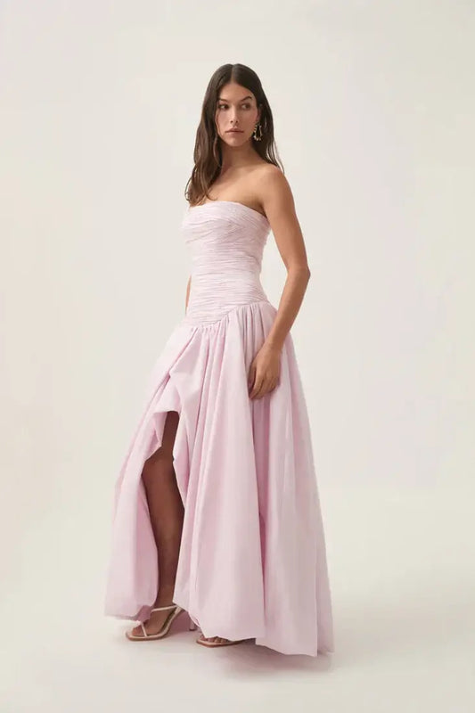 Model wearing a luxurious Violette Bubble Hem Maxi Dress with strapless ruched bodice and asymmetrical bubble hem.