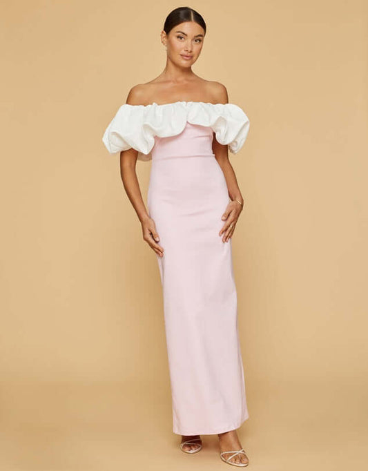 Model wears Venus Gown curates a collection of timeless designs. Showcasing the pink dress and white frills.