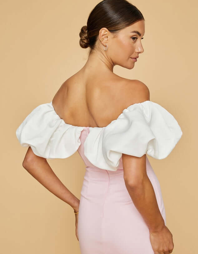 Cotton-rich fabric with a touch of nylon. Pink slim fit of dress with white off the shoulder ruffled details. Model showing back.