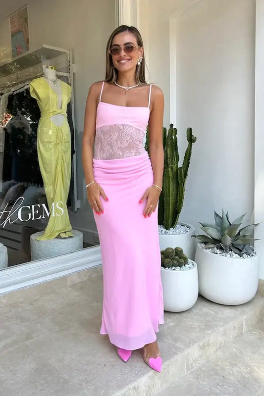 Model wearing Gabriel Maxi Dress in Pink Sorbet, showcasing lace bodysuit and cowl front skirt, styled with pink heels.
