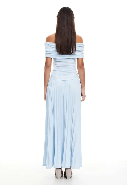 Model wearing a light blue off-the-shoulder maxi dress from Lioness, showcasing a pleated skirt and elegant silhouette.