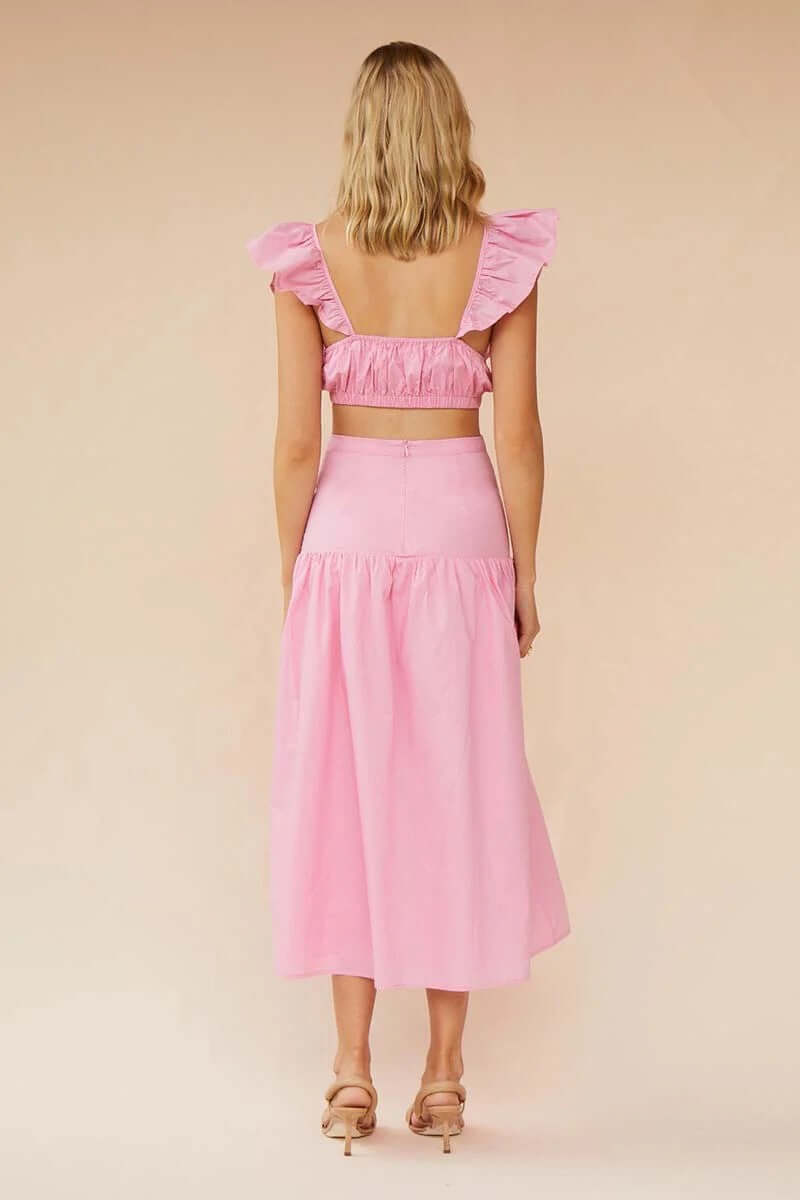 Back view of the Rosanna Ruffle Cut Out Midi dress in pink, featuring a ruffled top and a flowing skirt.