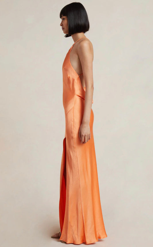 Model wearing the Annika Cowl Maxi Dress in Sorbet by Bec and Bridge. Showcasing side of dress with halter neck and rouleau straps
