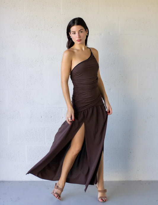 Model wearing the Lena Maxi Dress featuring a one-shoulder design and side leg split, showcasing its flowing silhouette.