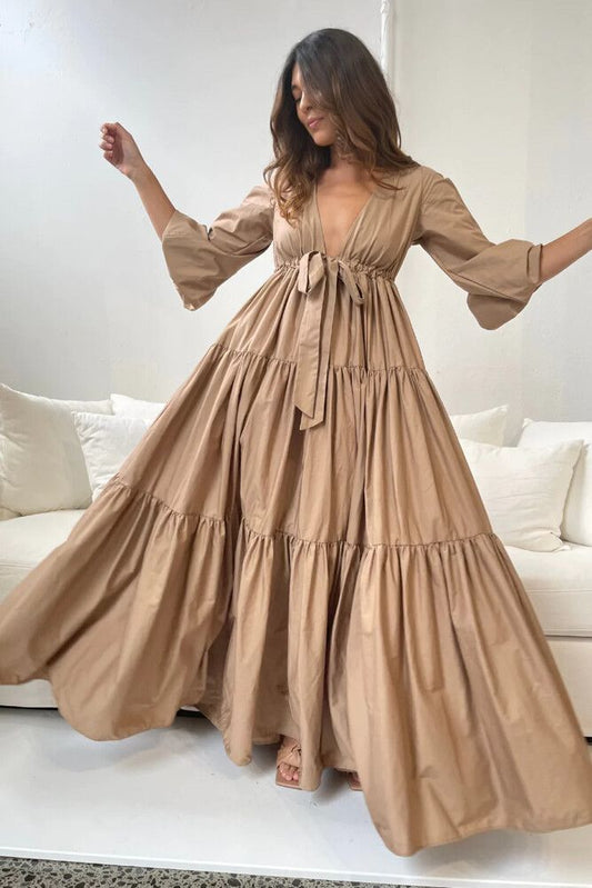 A Winters Tale Dress in tan, featuring a bow-tie and flared skirt, perfect for special occasions.