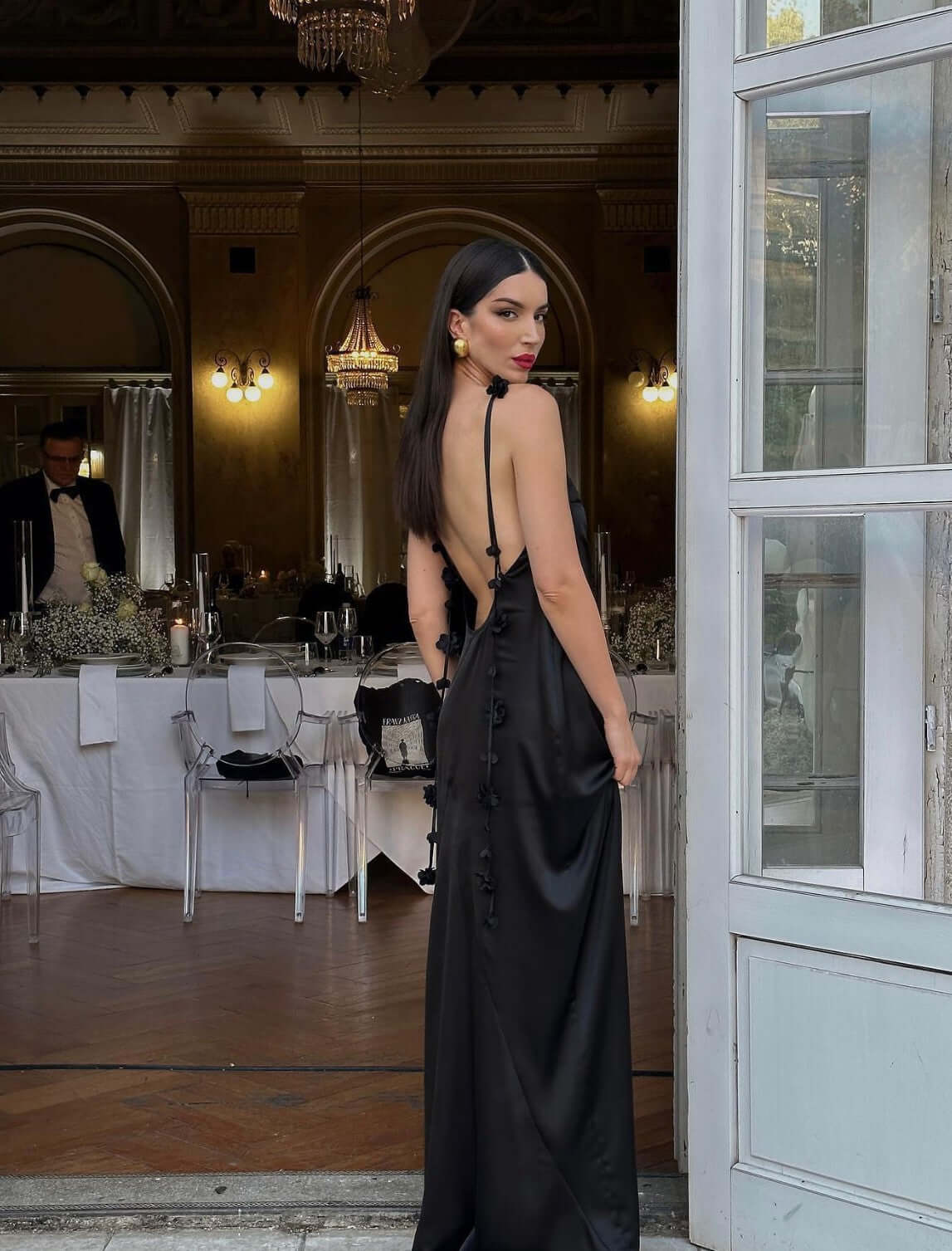 Model showcasing the Elenora Gown by Meshki. The 3D floral strap gracefully extends across the back