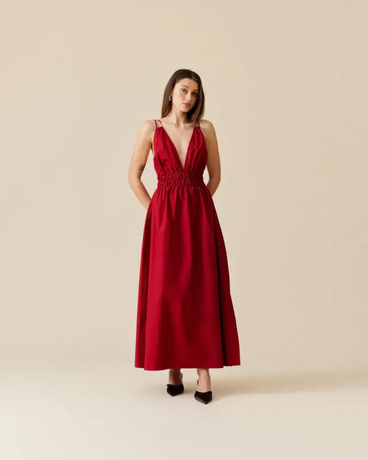 Model wearing and showcasing front of Ruby Hero Maxi Dress in Red. Double strap stunner featuring a daring plunge neckline.