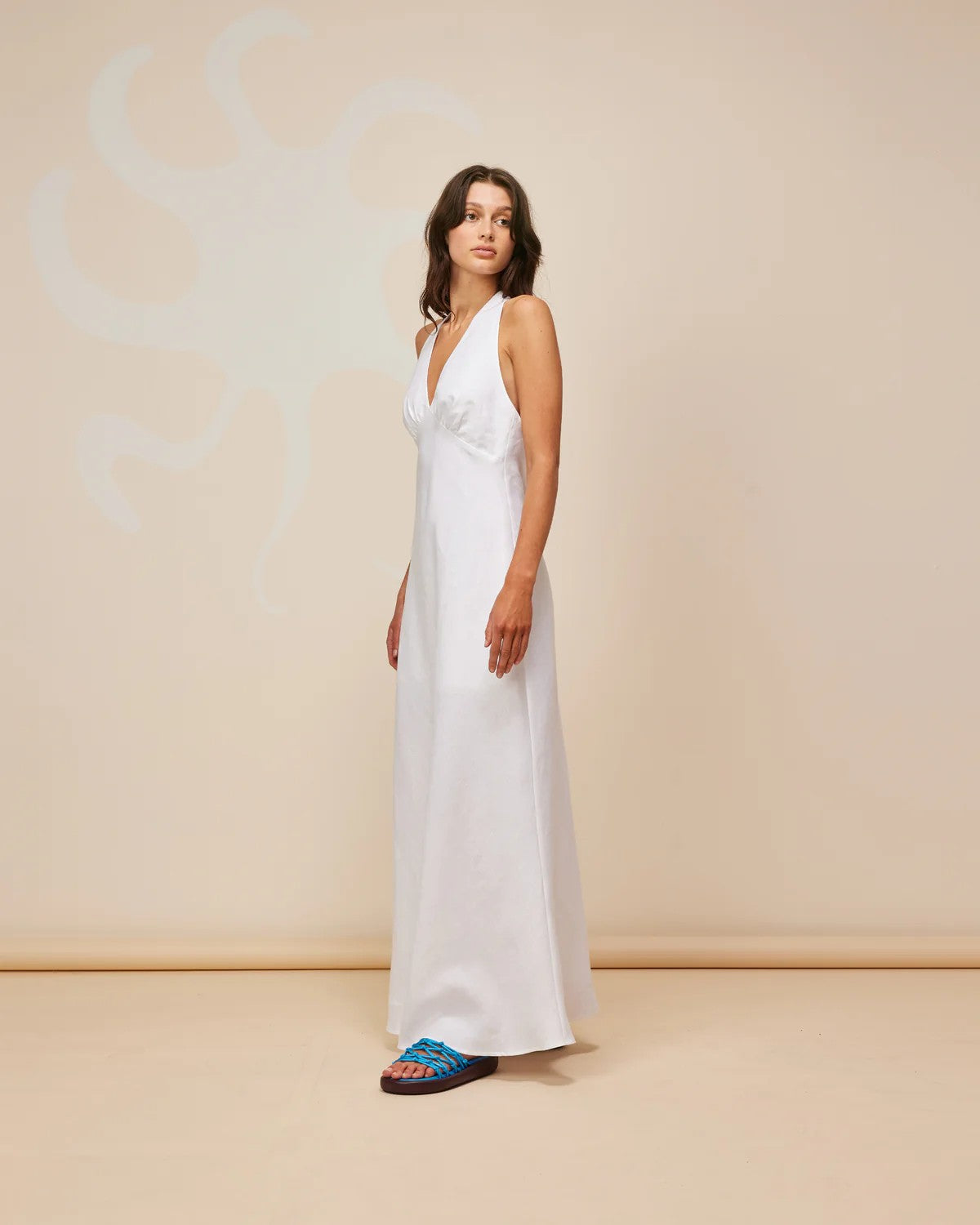 Ava Linen Halter Maxi Dress in crisp white linen, featuring a backless design and wide tie, perfect for summer events.