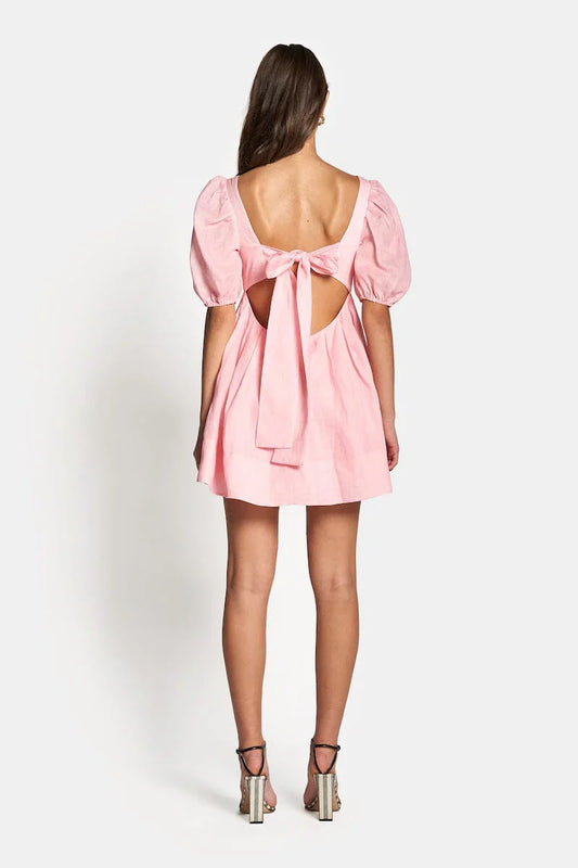 Aerin Open Back Tie Mini Dress in Baby Pink showcasing the tie-up open back and pleated skirt.